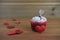 Romantic cup cake in red and white with a miniature person figurine holding a sign board on top and red love hearts