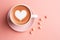Romantic cup of latte coffee with heart shape art on foam, top view on love background