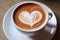 Romantic cup of latte coffee with heart shaped art on foam, top view, love background