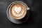 Romantic cup of latte coffee with heart shaped foam art on top, top view on love themed background
