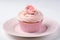 Romantic cupcakes with pink frosting and sugar rose on plate