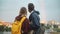 Romantic date of beautiful happy couple. Hipster man and woman holding the box, enjoying the panorama of the city.