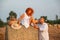 Romantic date on a freshly cut field near a haystack