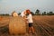 Romantic date on a freshly cut field near a haystack