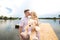 Romantic date surprise. A young guy and a girl on a pier overlooking the lake. The guy gives the girl a teddy bear