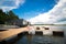 Romantic date surprise. A young guy and a girl on a wooden pier. Hug and kiss while sitting on the pier. Romantic love story