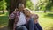 Romantic date of two retired people, man hugging wife with flower bouquet