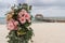 Romantic decoration with pink roses of a beach wedding on the beach with sea in the background