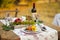 Romantic dinner in the autumn garden, table setting for a nice dinner. Wine, fruit, pomegranate and flowers. Picnic in the open