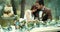 Romantic dinner in misty forest. Attractive sensitive loving couple in vintage cloth is tenderly hugging at table