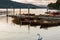 Romantic dusk scene of a beautiful mute swan and moored boats in Lake Windermere