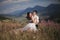 Romantic fairytale couple newlyweds kissing and embracing on a background of mountains