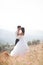 Romantic fairytale couple newlyweds posing at sunset on a background of mountains