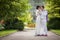 Romantic fairytale married couple in white clothes kissing in ga