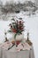 Romantic festive Christmas table setting. Bouquet with amaryllis flowers, holly berries, eucalyptus. Glass of wine