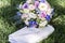 Romantic fresh wedding bouquet and handbag on green grass