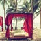 Romantic gazebo lounge at tropical resort. Beach beds among palm