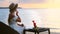 Romantic girl having luxurious seafood dinner on beach, enjoy view of sunset sea