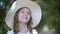 Romantic girl portrait in white summer hat. Close up face smiling girl teenager in white hat in summer park. Pretty girl