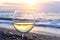 Romantic glass of wine sitting on the beach at colorful sunset Glasses of white wine against sunset, white wine on the sky