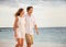 Romantic happy couple walking on beach at sunset