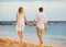 Romantic happy couple walking on beach at sunset