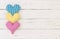 Romantic hearts border of colorful fabric on white wooden background with space for text