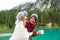 Romantic kiss of a couple of adults visiting an alpine lake at Braies Italy