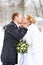 Romantic kiss happy bride and groom on winter
