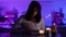 Romantic lady is reading book by candlelight at night in dark room