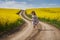 Romantic latino woman barefoot on a road in canola field