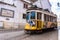 Romantic Lisbon street with the typical yellow tram, Portugal