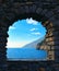 Romantic look at Portovenere on mediterranean sea through a historic medieval stone arch window. Liguria . Italy
