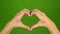 Romantic love sign with hands on green screen