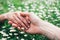 Romantic lovers touching hands on spring flowers