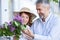 Romantic mid adult gray-haired man giving bouquet of lilacs to his wife