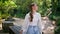 Romantic model posing summer forest leaning on table. Woman enjoy green nature