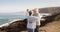 Romantic moment for a senior couple with grey hair dancing on the cliff  at sunrise. Positive retirement. Ocean and mountains in