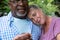 Romantic multiracial senior couple spending leisure time together in backyard