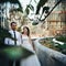 Romantic newlyweds posing in botanic garden, glass structure bac