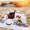 Romantic picnic with wine on sandy beach at amazing evening sunset