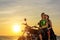 Romantic picture with a couple of beautiful stylish bikers at sunset. Handsome guy with tatoo and young sexy woman enjoy