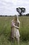 Romantic portrait of bohemian blonde in field of grass