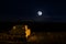 Romantic scene of old vintage car with couple inside and Moon on sky at night. Silhouette love and car on Full Moon Background. Se