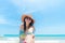 Romantic scene of young love couple vacations in the beach. Hand man holding hand woman in dress and hat walking