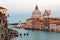 Romantic scenery of Venice bathed in dusk rosy light, with boats & ferries cruising on Grand Canal and landmark cathedral Basilica