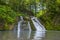 Romantic secluded spot. Small waterfall in quiet green mountain forest