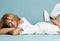 Romantic sensual smiling young redhead woman in shorts and crop top, white oversize clothes is lying on floor