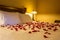 Romantic setting with rose petals on bed