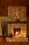 A romantic setting by a stone fireplace with candles and logs burning in the mountainside cabin